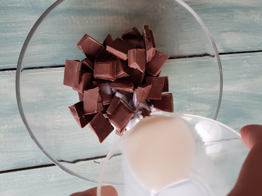 se adaugă laptele peste bucățile de ciocolată
